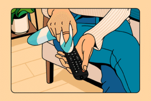 A girl is cleaning tv remote sitting on a chair